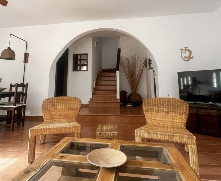 Salón con arco y escalera al piso superior